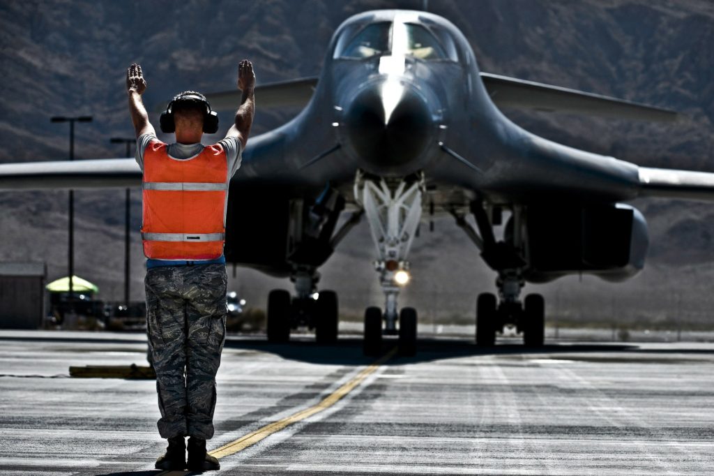 US Air Force picture of a plane on the runway with someone on the ground directing it